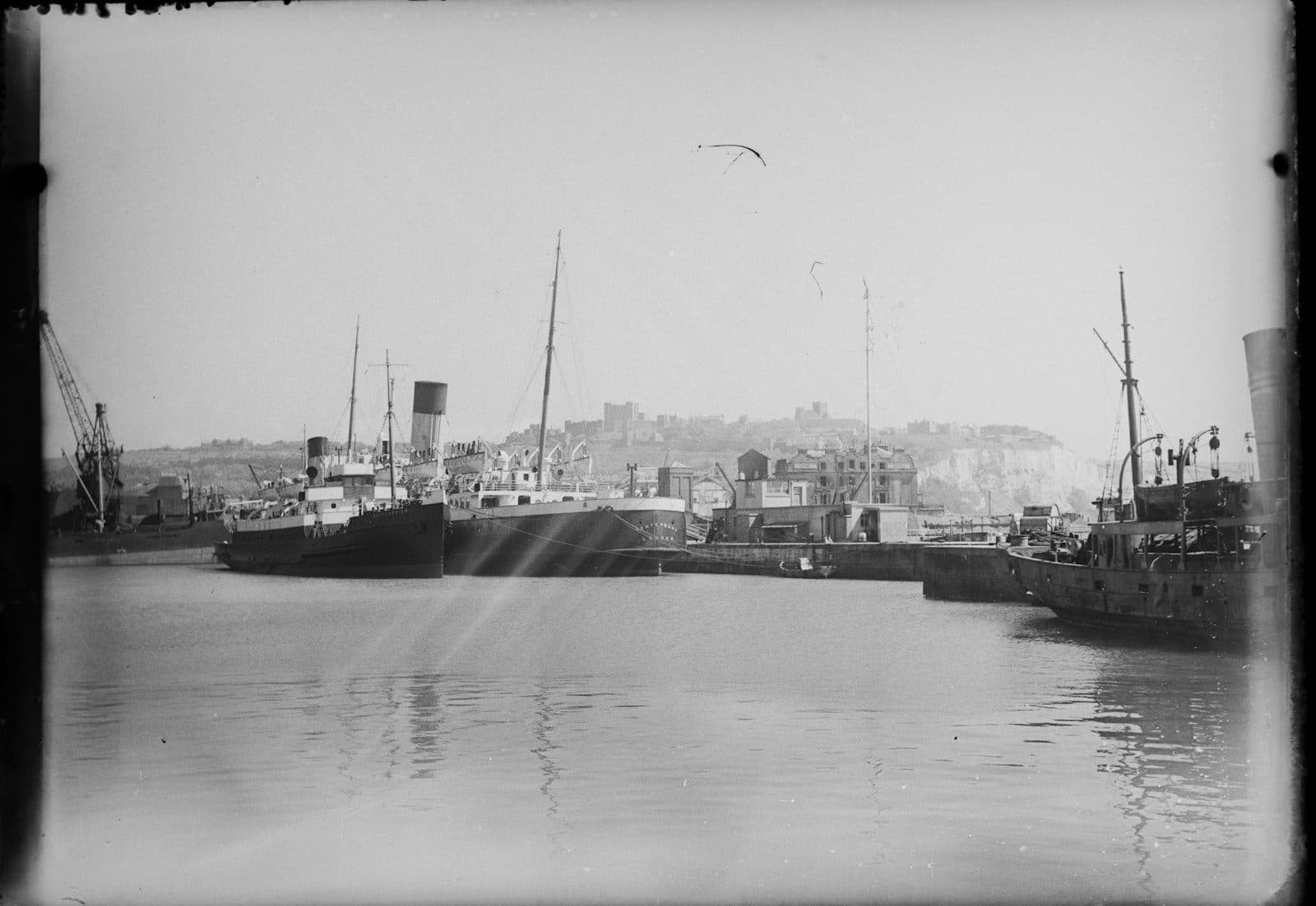 Fotografía histórica en blanco y negro de barcos de carga en un puerto